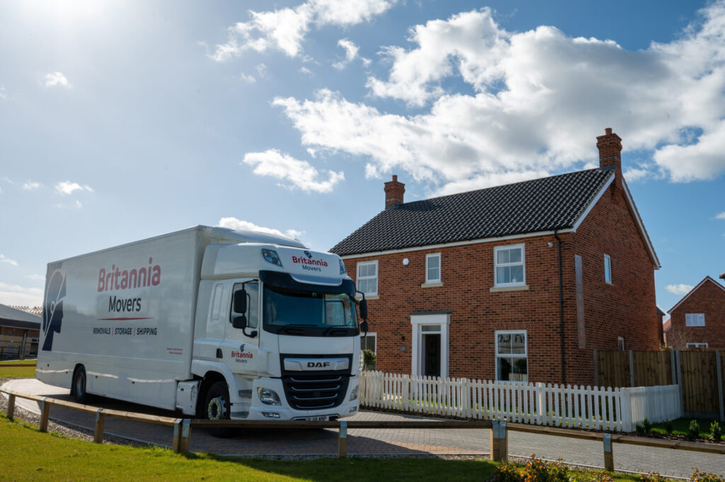 large_truck_outside_house (1) Britannia Movers truck outside new home on sunny day