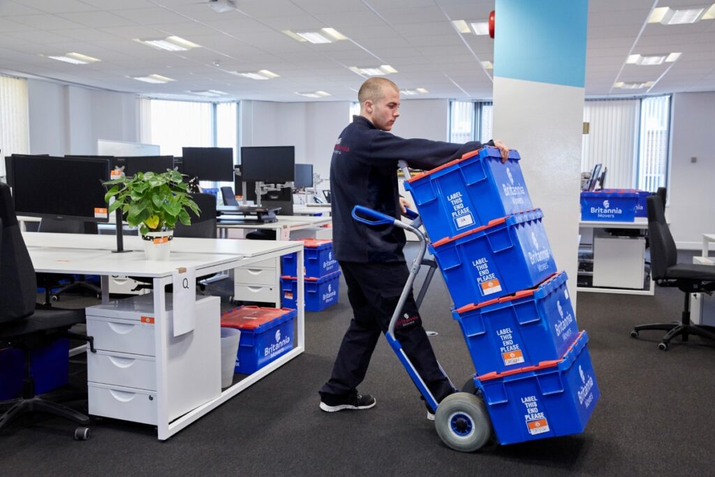 commercial moving team crates on a trolley
