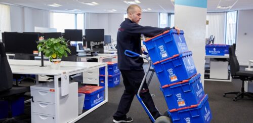 commercial moving team crates on a trolley