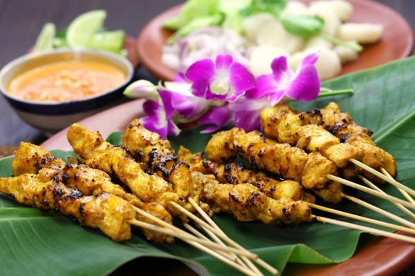 Chicken satay on banana leaf and purple orchids